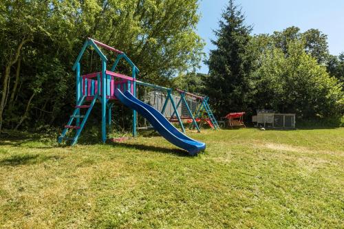 a playground with a slide in the grass at db staycation ferienpark in Niedenstein