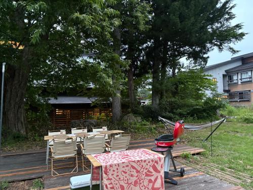 a patio with a grill and tables and chairs at Square 8 HAKUBA RETREAT by UNPLAN in Hakuba