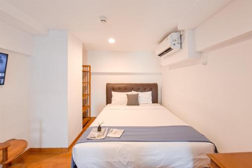 a small bedroom with a bed in a room at Cozy Stay and Comfy Studio Loft Kingland Avenue Apartment By Travelio in Tangerang