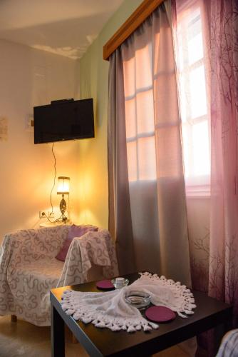 a room with a bed and a table and a window at Melina's Sunset in Myrties