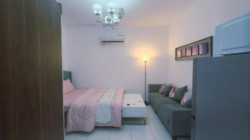 a living room with a bed and a couch at Harmonic properties in Abu Dhabi