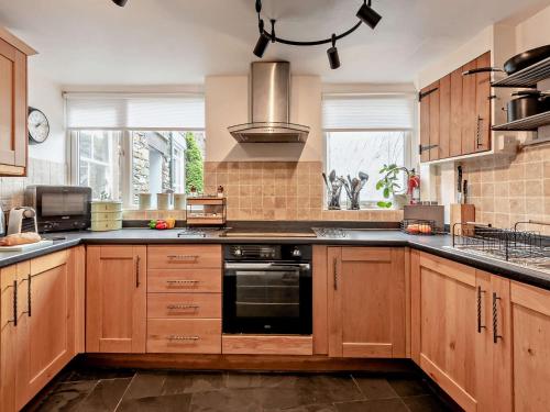 a kitchen with wooden cabinets and a stove top oven at 2 Bed in Grasmere SZ500 in Grasmere