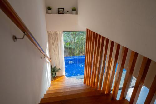 a staircase in a house with a large window at Dia Hotels and Homes Nerul Goa - Villas and Apartments in Nerul