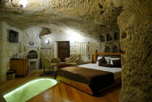 a bedroom with a bed in a stone room at Harman Cave Hotel in Goreme