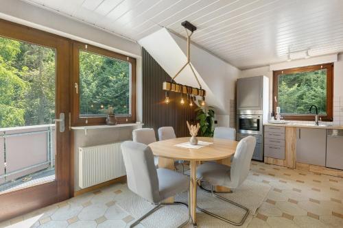 a kitchen and dining room with a wooden table and chairs at Wohung zum Ausblick in Plettenberg