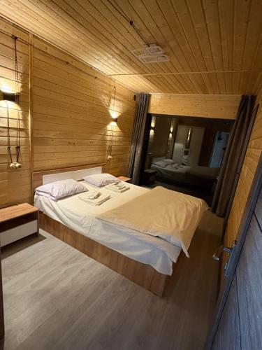a bedroom with a large bed in a wooden room at Old Byurakan Cottage in Byurakan