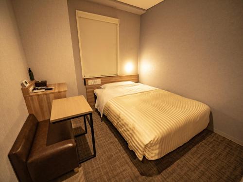 a hotel room with a bed and a chair at Super Hotel Shiga Nagahama Tennen Onsen in Nagahama