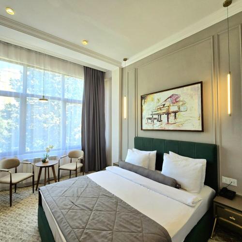 a hotel room with a bed and a table and chairs at Maestro Address Baku Hotel in Baku