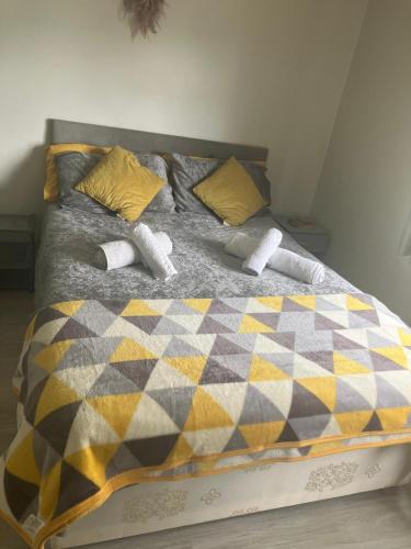 a bed with a checkered blanket and pillows at Welcoming Home Close to Transport Links in Thornton Heath