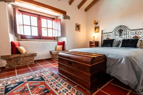 a bedroom with a bed and a bench in a room at Alto Paraíso Boutique Hotel in Reguengo Grande