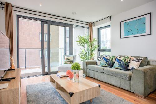 a living room with a couch and a table at Peaceful, cosy - modern 2 Bedroom entire Flat in Canary Wharf Close to the 02 in London