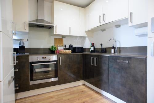 a kitchen with stainless steel appliances and wooden floors at Peaceful, cosy - modern 2 Bedroom entire Flat in Canary Wharf Close to the 02 in London
