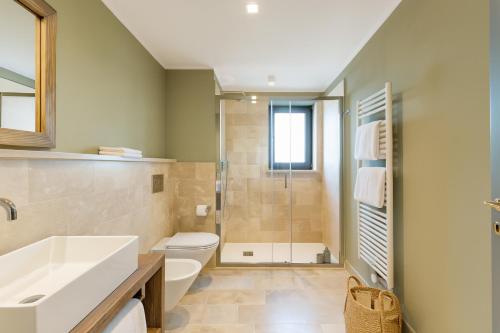 a bathroom with a toilet and a sink and a shower at Palazzo Massaini - Le Scuderie in Pienza
