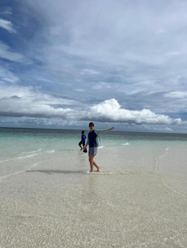 two people playing with a frisbee on the beach at Amaro Homestay in Nuhu Tawun