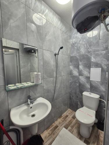 a bathroom with a toilet and a sink at Студио Лазур с Безплатен Паркинг in Pomorie
