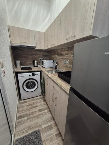 una piccola cucina con fornelli e frigorifero di Студио Лазур Поморие a Pomorie