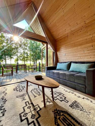 a living room with a couch and a table at Ritopia Glamping in Kovilj