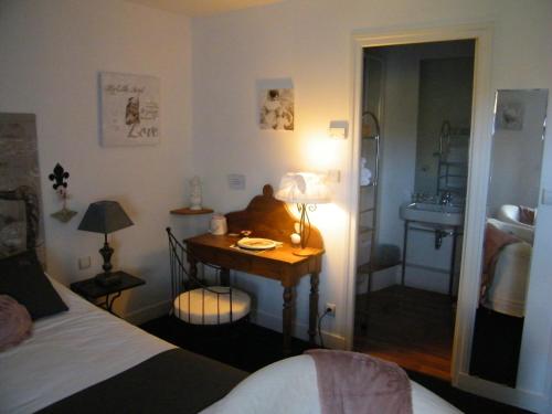 a bedroom with a bed and a desk with a sink at Logis-Hôtel Côté-Rivage in Badefols-sur-Dordogne