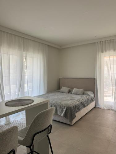 a bedroom with a bed and a table and chairs at Lulu Lustica bay in Tivat