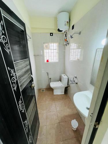 a bathroom with a toilet and a sink at Harmony residency in Kammasandra