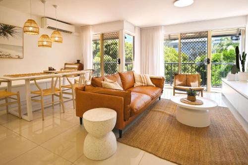 a living room with a couch and a table at Luxe Coastal Escape, Sunny Coast in Maroochydore