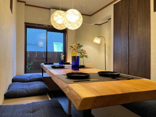 a dining room with a wooden table and chairs at nestay house osaka imazato in Osaka