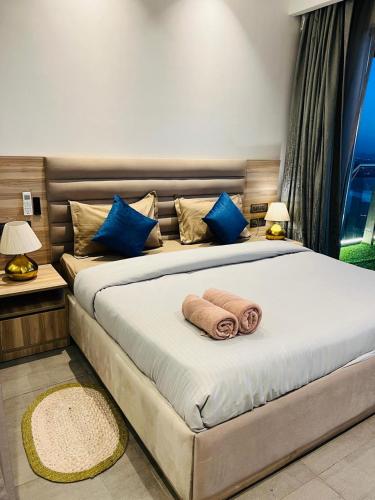 a bedroom with a bed with a towel on it at Eden Suite - 30th floor in Noida