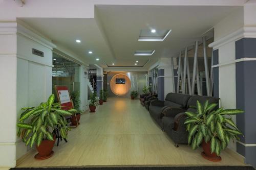 an office hallway with couches and potted plants at Hotel Athome & Serviced Apartments by Deccan Serai Hotels in Hyderabad