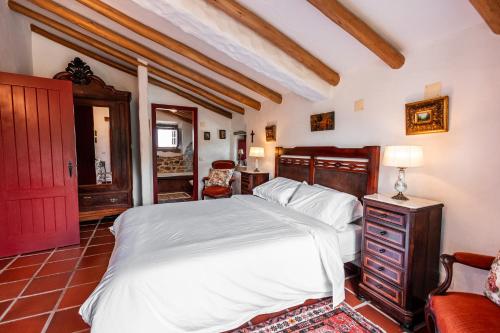 a bedroom with a white bed and a red door at Alto Paraíso Boutique Hotel in Reguengo Grande