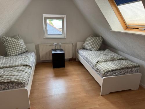 a attic room with two beds and a window at Ferienwohnung Reinsdorf in Büddenstedt
