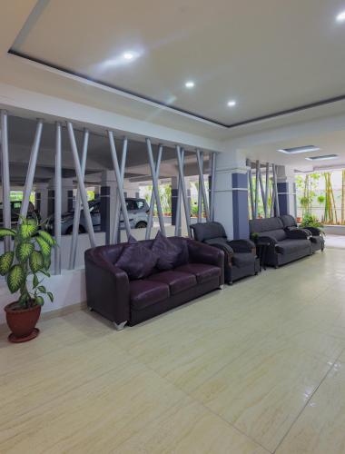 a large living room with couches and a plant at Hotel Athome & Serviced Apartments by Deccan Serai Hotels in Hyderabad