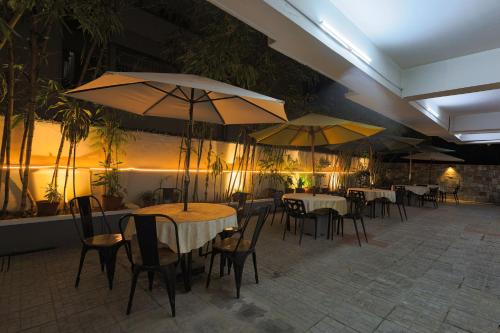 a restaurant with tables and chairs and umbrellas at Hotel Athome & Serviced Apartments by Deccan Serai Hotels in Hyderabad