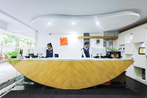 two people sitting at a counter in an office at Hotel Athome & Serviced Apartments by Deccan Serai Hotels in Hyderabad