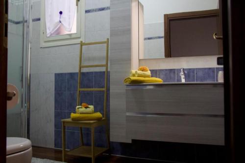 Un baño con toallas amarillas sobre un mostrador y un espejo. en Appartamento Mandiri, en San Casciano in Val di Pesa