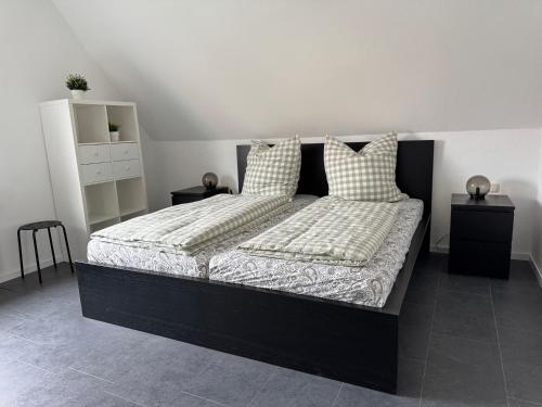 a bedroom with a black bed with two pillows at Ferienwohnung Reinsdorf in Büddenstedt