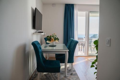 a dining room with a table and chairs and a window at Suite Apartment Sveti Stefan in Sveti Stefan
