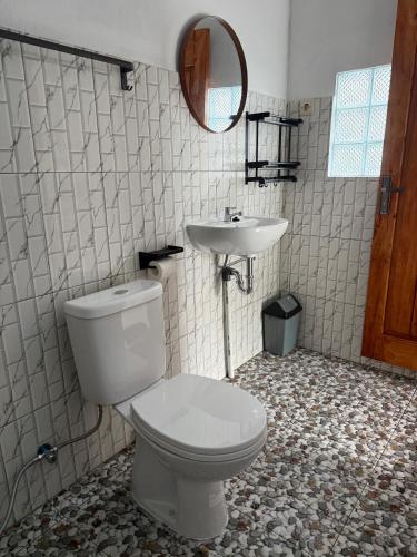 a bathroom with a toilet and a sink at Cena Homestay in Mantaak