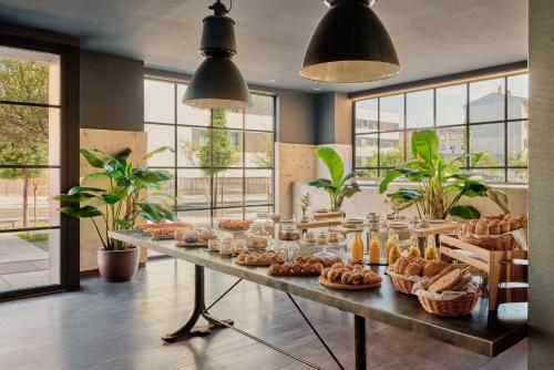 a long table with pastries and baskets of bread at Hotel Pamplona Plaza in Pamplona