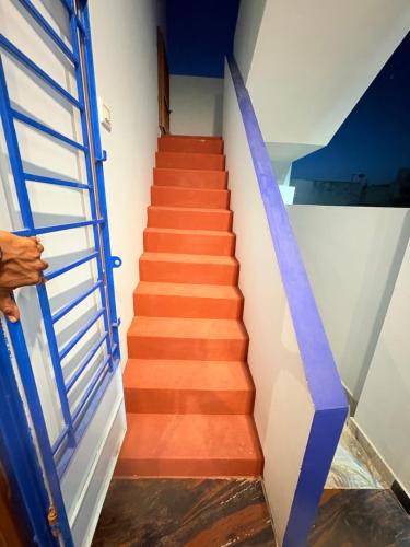 a staircase with a blue door and a blue ribbon at Happy Madurai Home stay in Madurai