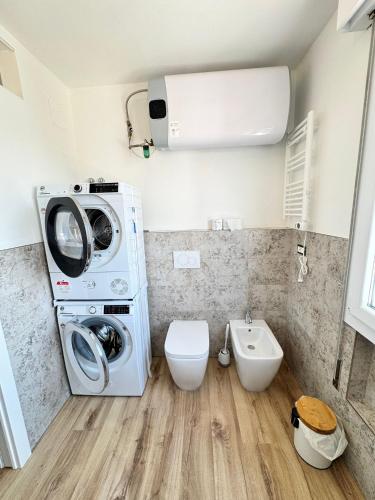 a bathroom with a washing machine and a toilet at Bulldog Venice Apartment in Venice-Lido