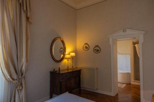 a room with a mirror and a lamp on a dresser at Villa Rinaldi in Montespertoli