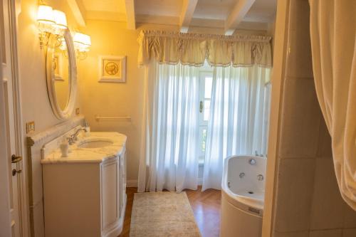 a bathroom with a sink and a mirror and a tub at Villa Rinaldi in Montespertoli