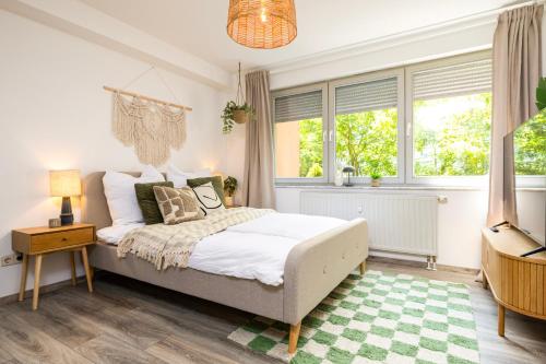 a bedroom with a bed and two windows at StayTime - Canopy Loft in Dresden