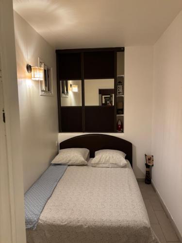 une chambre avec un lit avec deux oreillers dessus dans l'établissement 2 Pièces au cœur de Cagnes Sur Mer, à Cagnes-sur-Mer