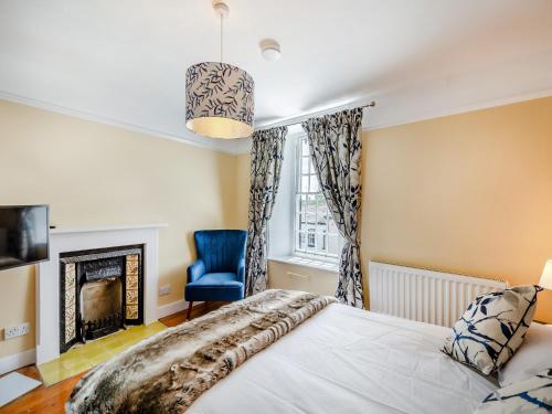 a bedroom with a bed and a fireplace at Cartmel Place in Cartmel