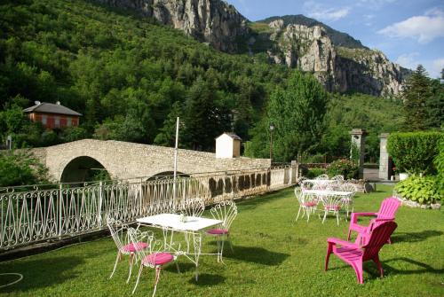 a group of tables and chairs with a mountain in the background at Le Mirval in La Brigue