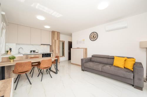 a kitchen and living room with a couch and a table at Poolside Hideout Apartments in Novalja