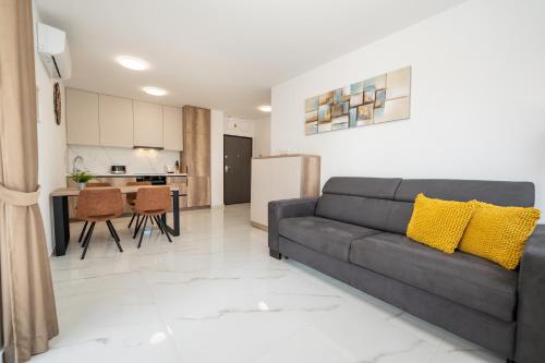 a living room with a couch and a kitchen at Poolside Hideout Apartments in Novalja