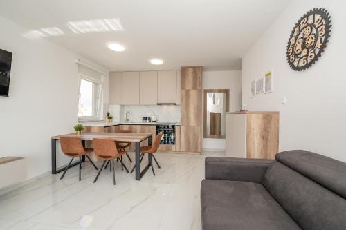 a kitchen and living room with a couch and a table at Poolside Hideout Apartments in Novalja