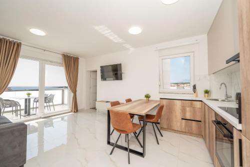 a kitchen and dining room with a table and chairs at Poolside Hideout Apartments in Novalja